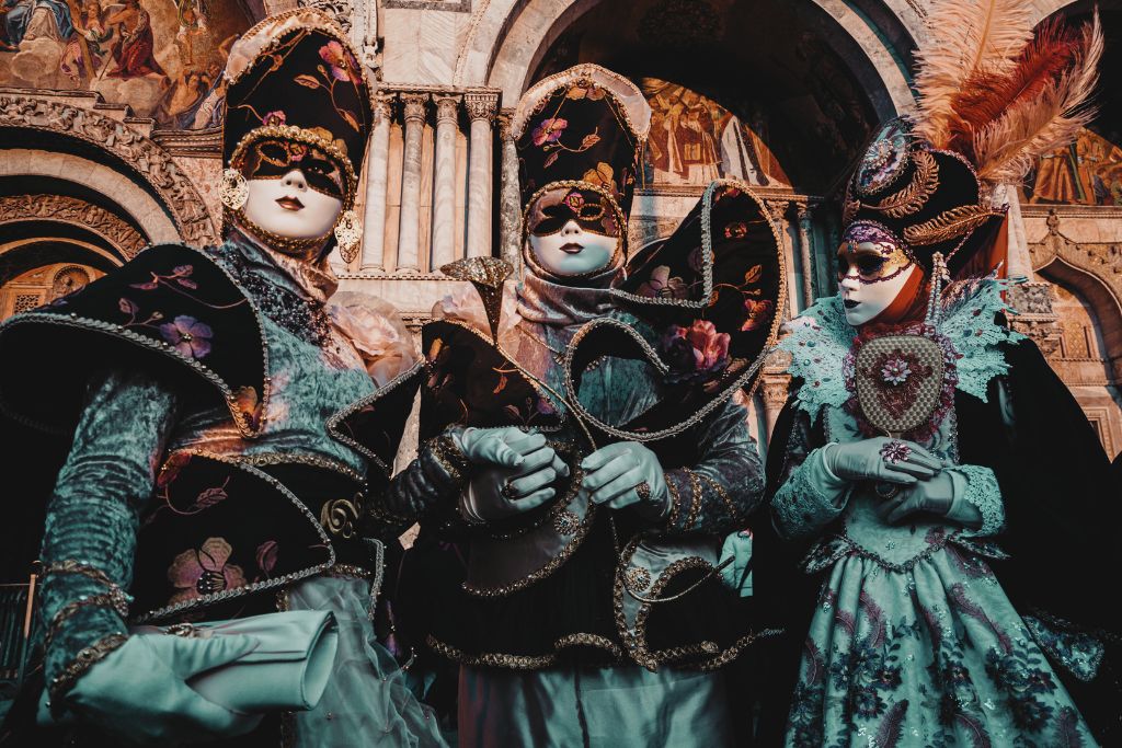 people dressed up in extravagant masks and costumes for the venice carnival - venice is worth visiting to experience the annual venice carnival